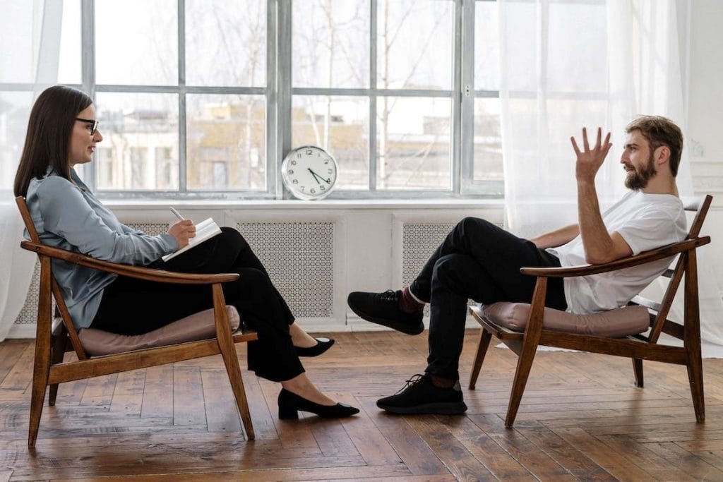 Person talking with therapist sitting in chairs