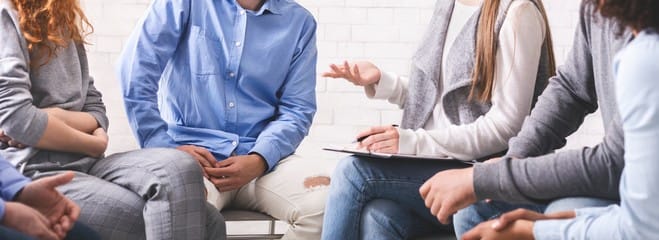 Therapist talking to a group of 3 patients